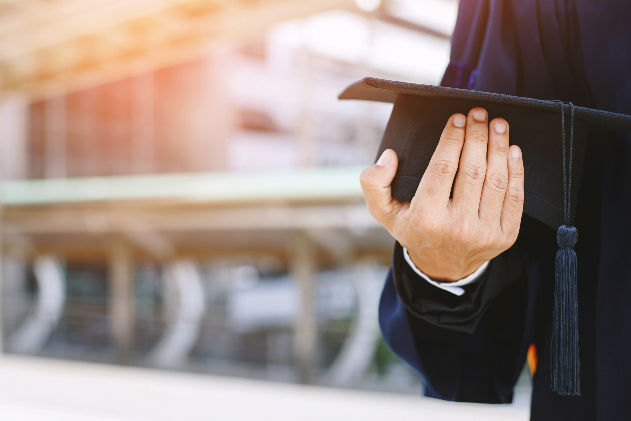 Graduate Holding a Mortarboard  